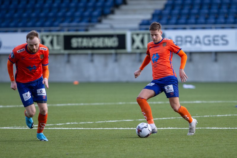 Håvard Mork Breivik spiller ballen framover i banen. Til venstre: Prøvespiller Bendik Rise fra Hødd. Foto: Srdan Mudrinic.