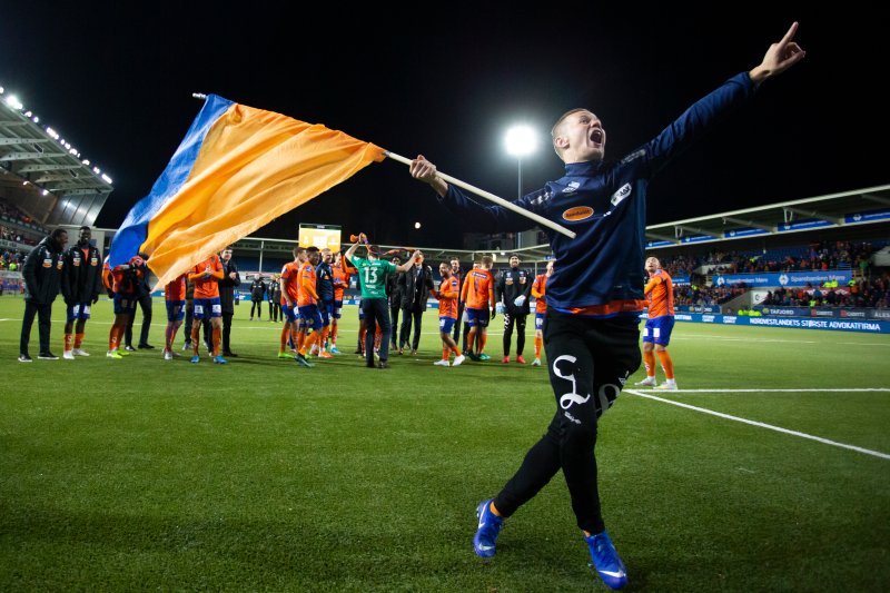 Aalesunds Ståle Stålinho Sæthre jubler med et flagg i hånden foran supporterne etter førstedivisjonskampen i fotball mellom Aalesund og Sandefjord på Color Line Stadion. Foto: Svein Ove Ekornesvåg / NTB scanpix